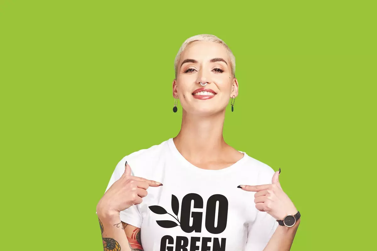 Frau mit kurzen Haaren mit GO GREEN T-Shirt vor grünem Hintergrund