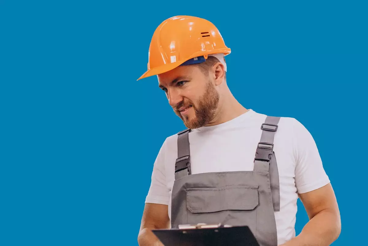 Mann in Produktion mit Helm vor blauem Hintergrund