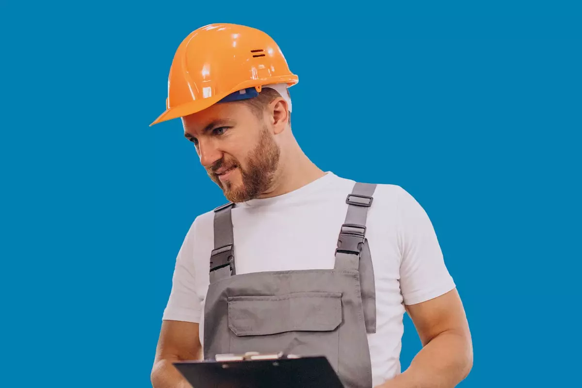 Mann in Produktion mit Helm vor blauem Hintergrund