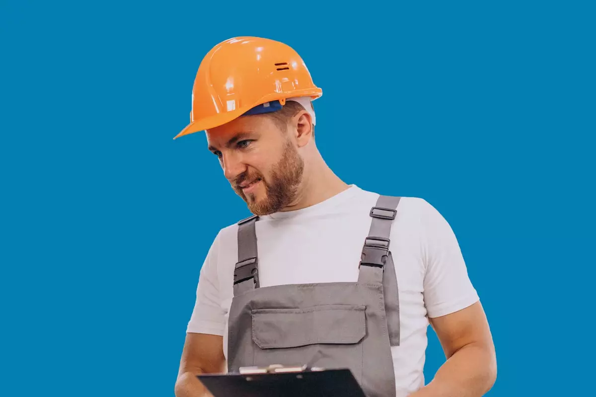 Mann in Produktion mit Helm vor blauem Hintergrund