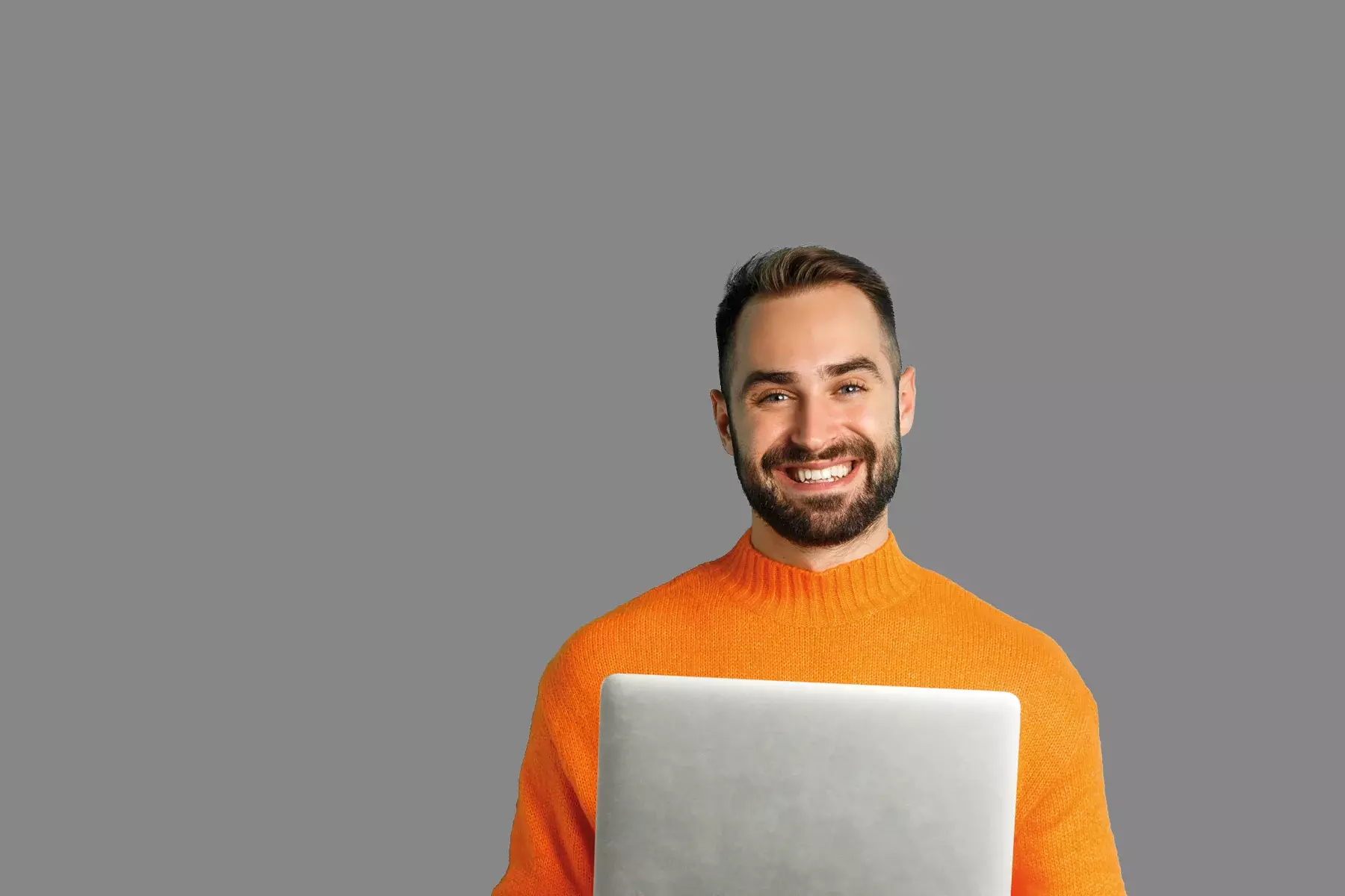 Junger Mann mit orangenem Pullover vor grauem Hintergrund