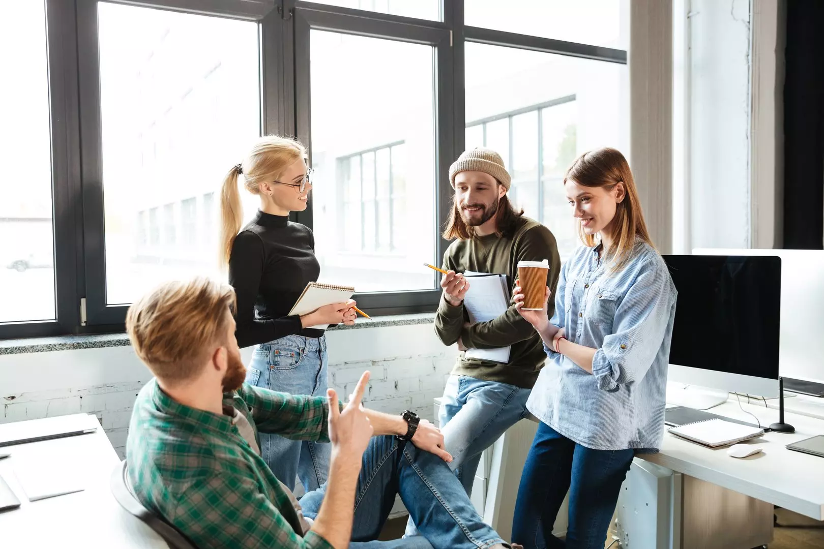 Colleagues standing in office and talking with each other