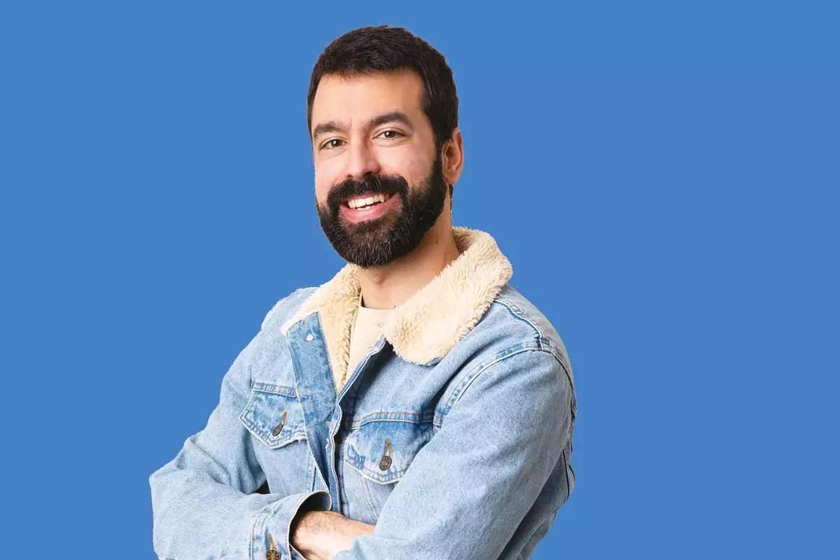 Mann mit Jeansjacke vor blauem Hintergrund