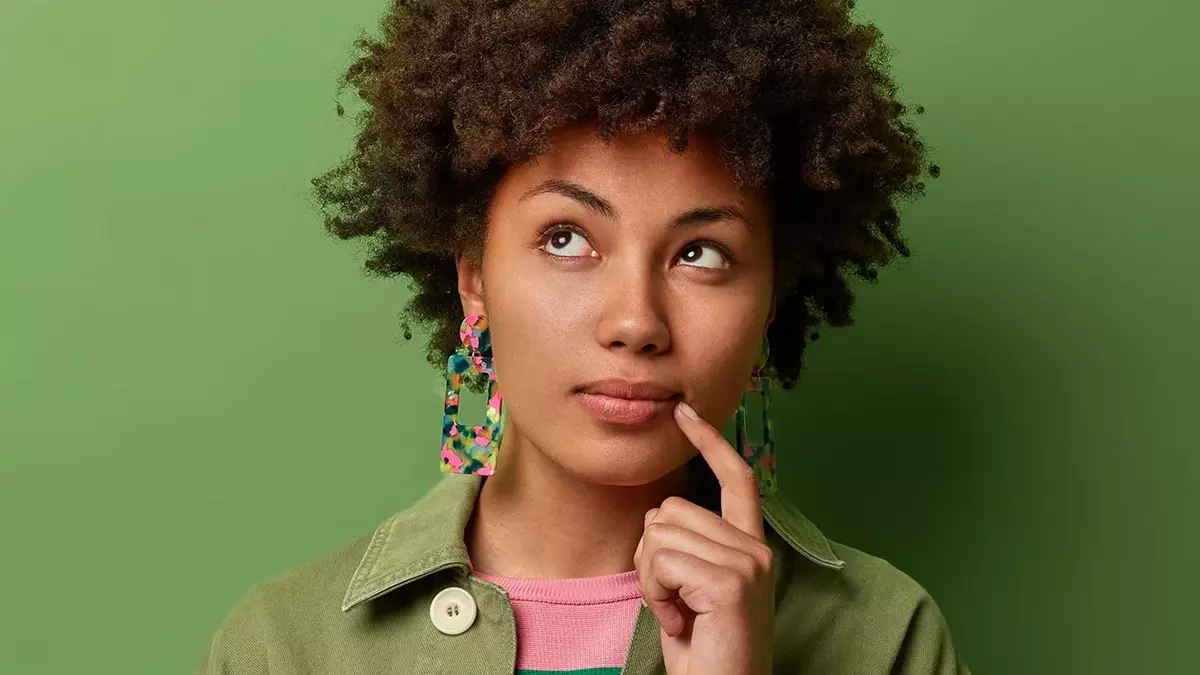 Frau mit braunem Haar und grüner Jacke vor grünem Hintergrund