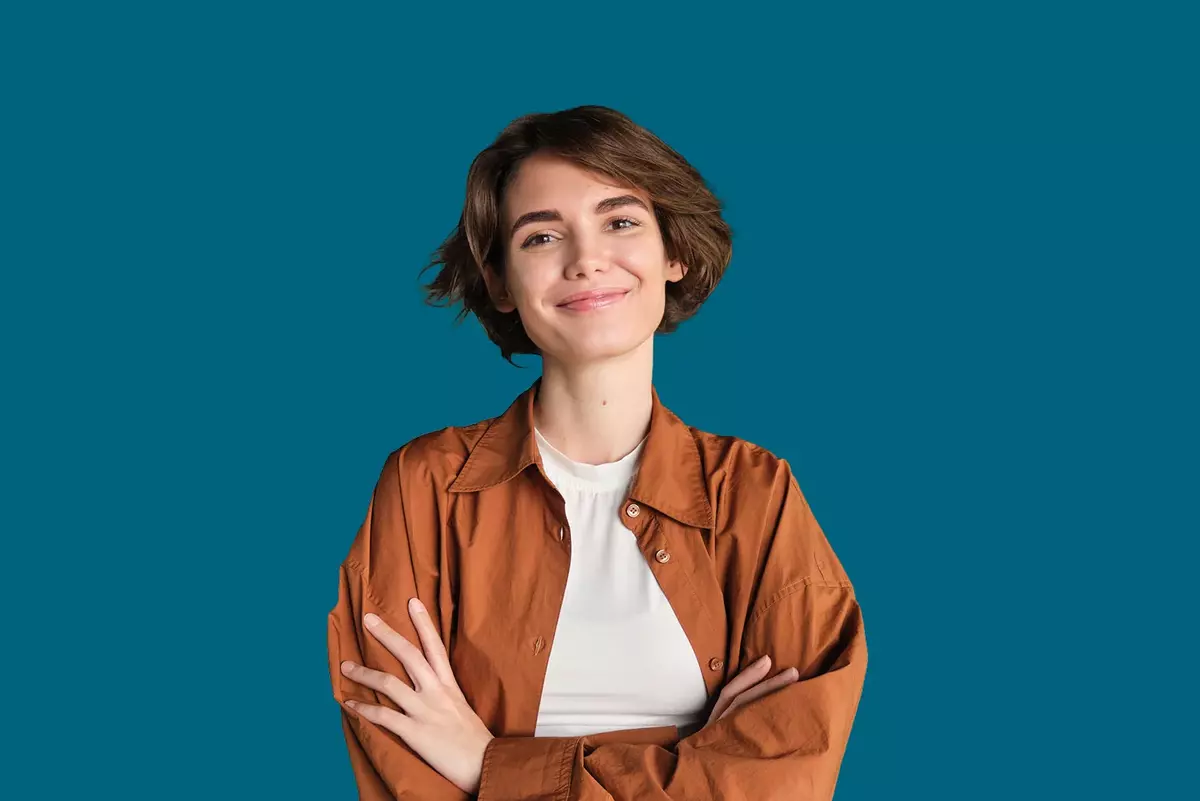 Junge Führungskraft mit brauner Bluse vor blauem Hintergrund