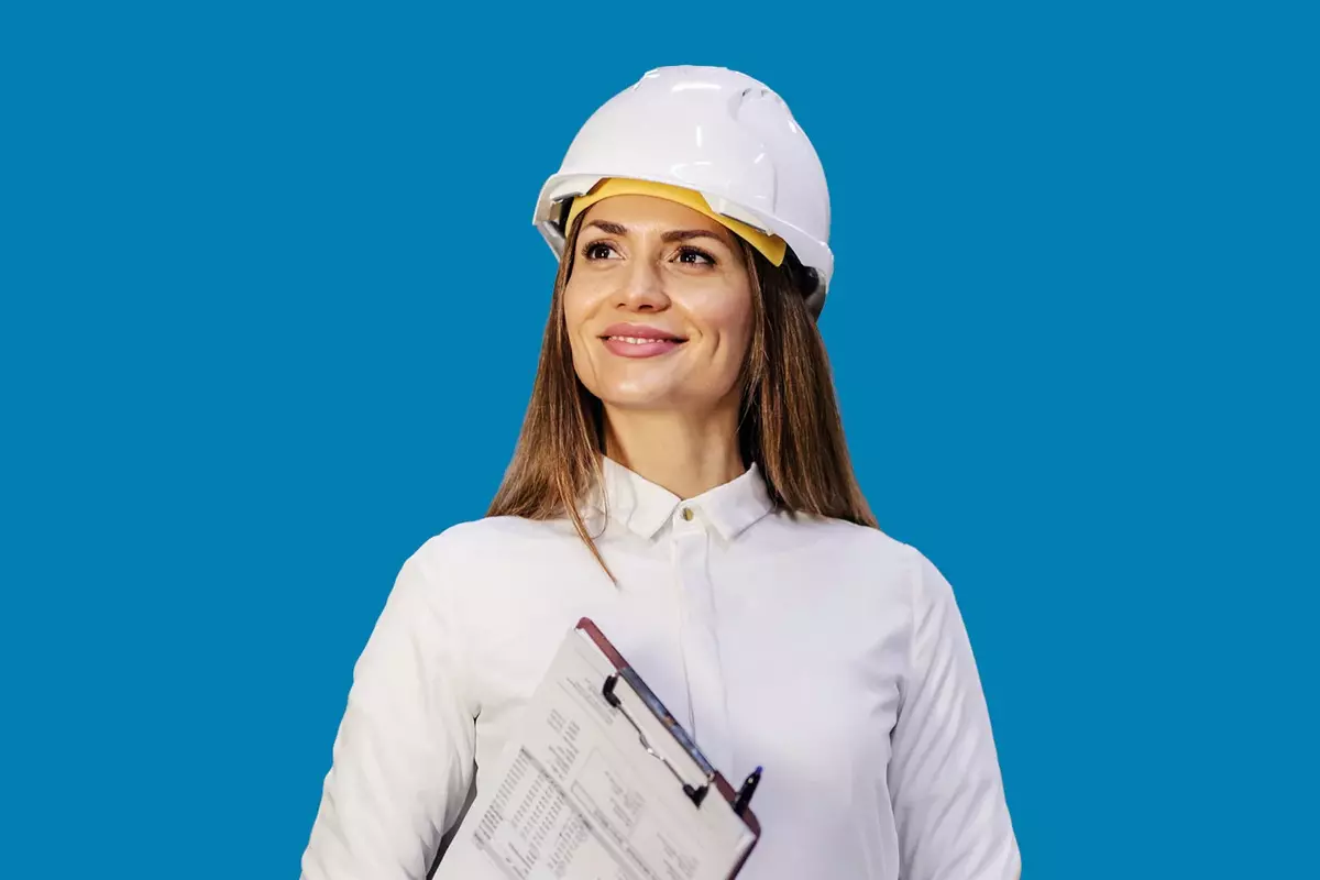 Frau in Produktion mit Helm vor blauem Hintergrund