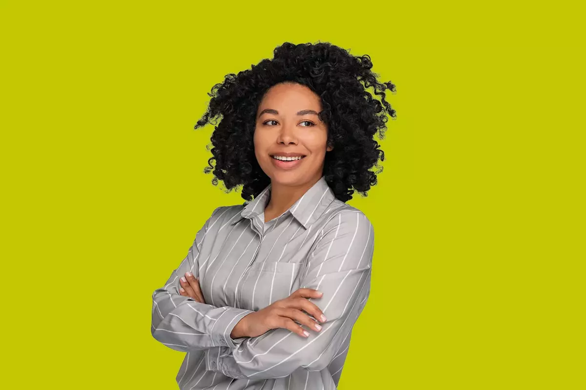 Frau mit grauem Hemd vor gelbem Hintergrund