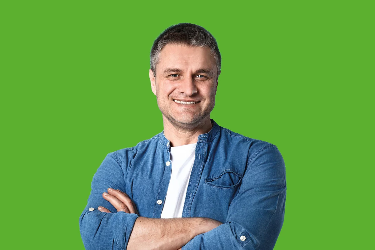 Mann in Jeanshemd vor grünem Hintergrund