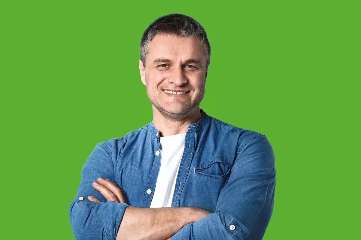 Mann in Jeanshemd vor grünem Hintergrund